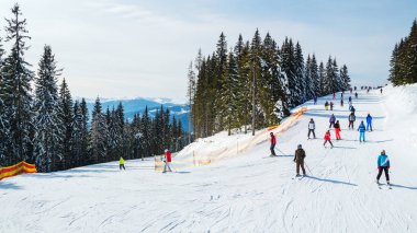bir karlı yolda birkaç kayakçı. Dağlarda kış tatili. Dağ kayak beldesinde Karpatlar