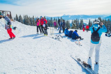 birkaç kayakçı dağın bekletin. Bir grup insan kar s üzerinde oturan Kayak elbiseli bir selfie yapar.