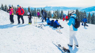 birkaç kayakçı dağın bekletin. Bir grup insan kar s üzerinde oturan Kayak elbiseli bir selfie yapar.