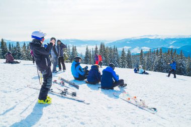 birkaç kayakçı dağın bekletin. Bir grup insan kar s üzerinde oturan Kayak elbiseli bir selfie yapar.