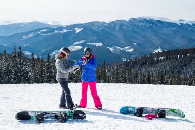 iki kadın kayak dağ selfie üstüne uygun. Kızlar snowboard ile kar üzerinde oturmak ve fotoğraflandı.