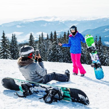 iki kadın kayak dağ selfie üstüne uygun. Kızlar snowboard ile kar üzerinde oturmak ve fotoğraflandı.