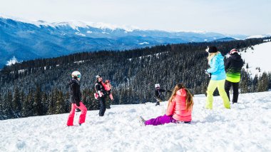 birkaç kayakçı dağın bekletin. Bir grup insan kar s üzerinde oturan Kayak elbiseli bir selfie yapar.
