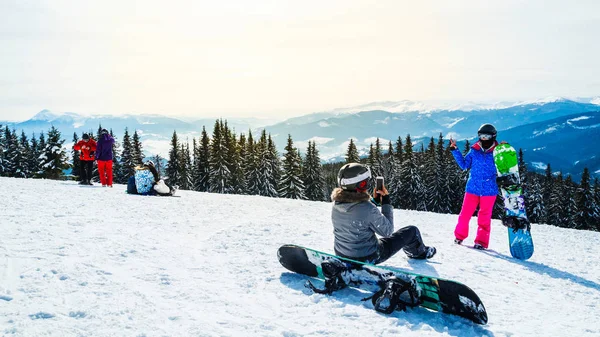 iki kadın kayak dağ selfie üstüne uygun. Kızlar snowboard ile kar üzerinde oturmak ve fotoğraflandı.