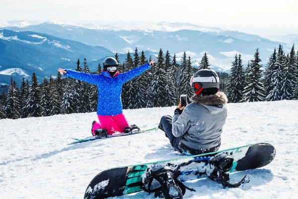 iki kadın kayak dağ selfie üstüne uygun. Kızlar snowboard ile kar üzerinde oturmak ve fotoğraflandı.