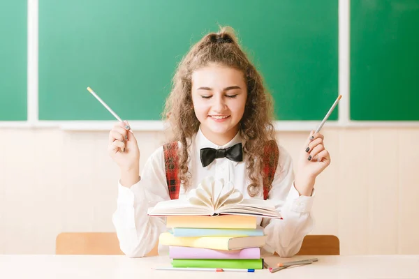 Schulmädchen Schuluniform Sitzt Ihrem Schreibtisch Mit Büchern Und Bleistiften Auf — Stockfoto