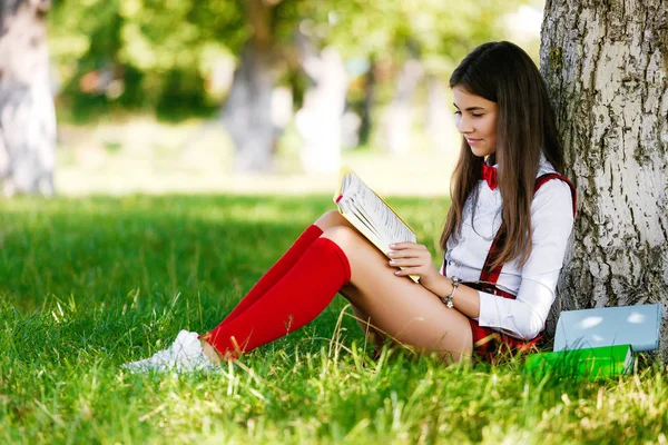 Jong Schoolmeisje School Uniform Zittend Het Gras Onder Een Boom — Stockfoto