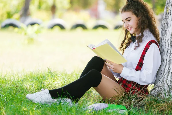 Jeune Écolière Uniforme Scolaire Assise Sur Herbe Sous Arbre Avec — Photo