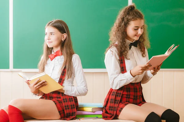 Deux Écolières Drôles Uniformes Scolaires Sont Assis Sur Fond Tableau — Photo