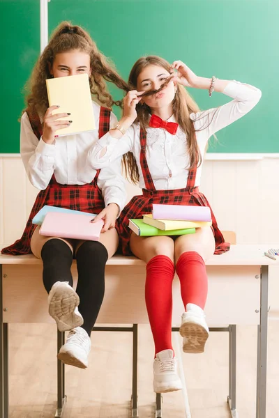 Dos Colegialas Divertidas Uniformes Escolares Están Sentadas Fondo Tablero Verde — Foto de Stock