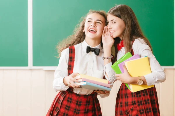Twee Grappige Schoolmeisjes Schooluniform Staan Met Boeken Achtergrond Van Het — Stockfoto