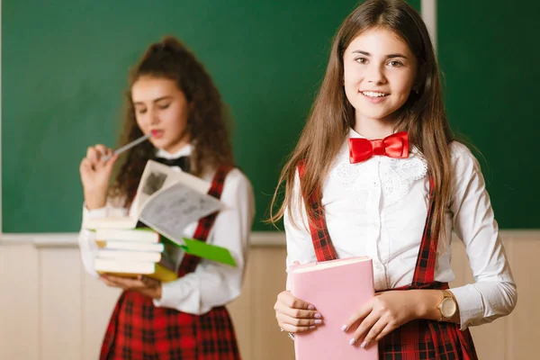 Two Funny Schoolgirls School Uniform Standing Books Background School Board — Stock Photo, Image