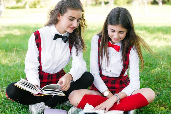 Dos Colegialas Divertidas Están Tumbadas Hierba Leyendo Libros Las Niñas — Foto de Stock