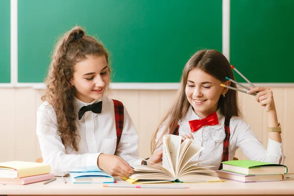 Дві Брюнетки Школярки Сидять Класі Столом Книгами Фоні Дошки Дівчата — стокове фото