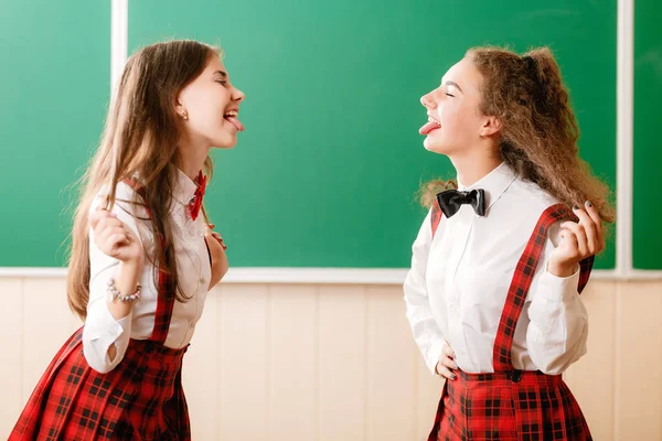 Δύο Μαθήτριες Μελαχρινή Στο Σχολείο Κόκκινες Στολές Στέκονται Μια Τάξη — Φωτογραφία Αρχείου