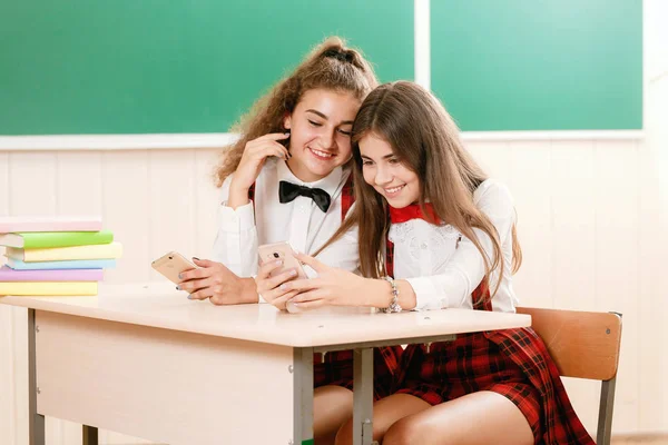 Due Studentesse Sono Sedute Alla Scrivania Classe Utilizzando Telefono — Foto Stock