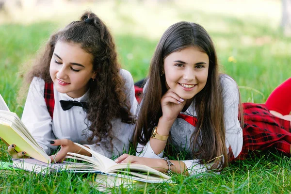 Due Studentesse Divise Scolastiche Rosse Sono Sdraiate Prato Verde Con — Foto Stock