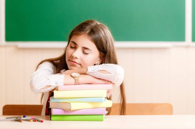 Masada kitaplar üzerinde uyku blackboard.girl arka plan kitapları ile okul masa başında oturan şirin esmer kız öğrenci