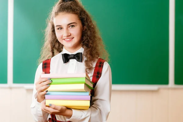 Schöne Schülerin Steht Klassenzimmer Und Hält Bücher Vor Dem Hintergrund — Stockfoto