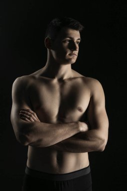 Güzel bir atletik vücut içinde düşük bir anahtar olan bir adam portresi. Çıplak bir gövde ile su kuyusu-yapılı adam kollarını göğsünde geçti.