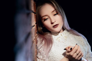 Genç güzel kadın tuğla duvara duruyor. Portre duvushki yakın çekim, hangi bir tuğla duvara dayanır