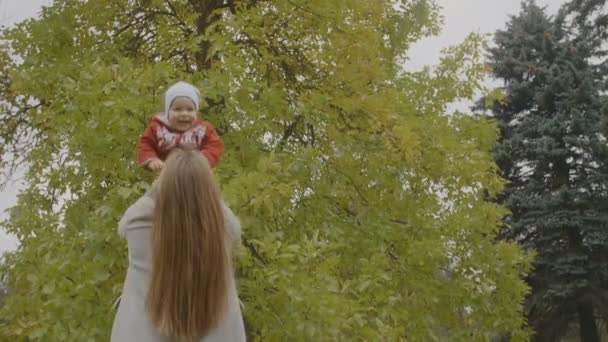 Slow Motion Mother Throwing Baby Girl Air Autumn Trees Background — Stock Video