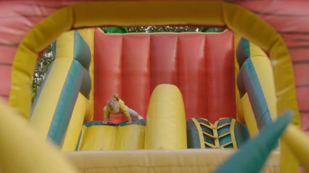 小女孩爬上去 在公园里的巨大充气滑块旁玩得很开心 孩子们爬上和骑在大充气滑块玩具 — 图库视频影像