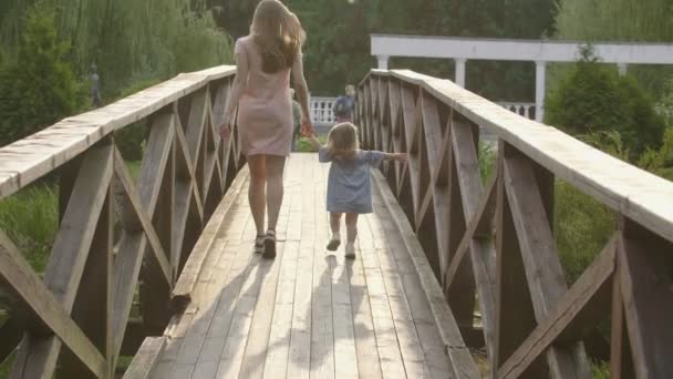 Zeitlupe Laufen Babys Mit Mama Sonnenuntergang Auf Einer Holzbrücke Hintergrundbeleuchtung — Stockvideo