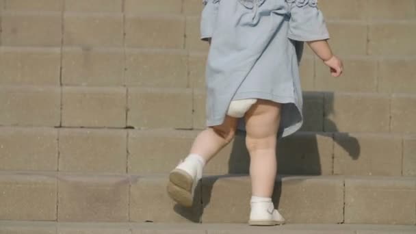 Una Niña Vestida Azul Sube Las Escaleras Bebé Camina — Vídeos de Stock