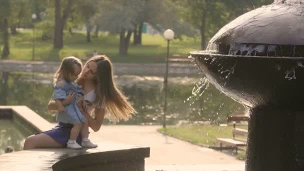 Kleine Mädchen Mit Mutter Sitzen Der Nähe Des Brunnens Und — Stockvideo