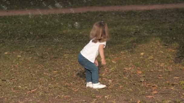 在日落的灯光下 女婴在夏日公园里为肥皂泡而奔跑 快乐的家庭吹肥皂泡在公园 — 图库视频影像