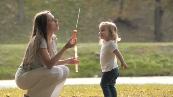 快乐的母亲和她的小女儿一起玩 吹和捕捉肥皂泡 — 图库视频影像