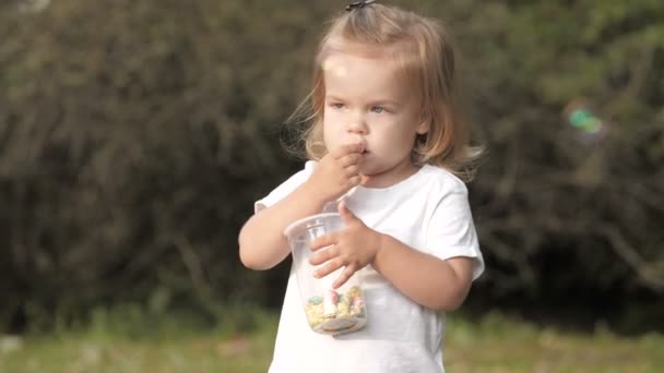 微笑的婴儿吃爆米花和看着相机的肖像 — 图库视频影像