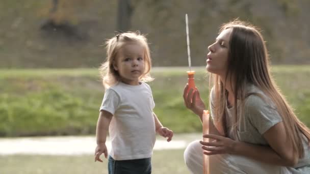Bambina Con Madre Fare Bolle Sapone Nel Parco Estivo Luce — Video Stock