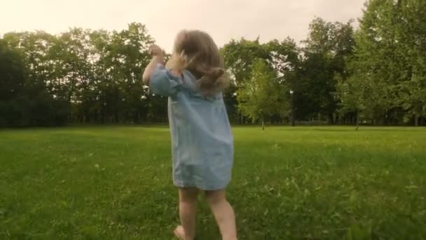 在公园的夏日阳光下 带着妈妈的女婴在草地上奔跑 宝贝玩得开心 慢动作 幸福家庭理念 — 图库视频影像