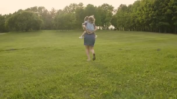Gün Batımında Bir Şehir Parkında Anneye Binen Kızı Yavaş Çekim — Stok video