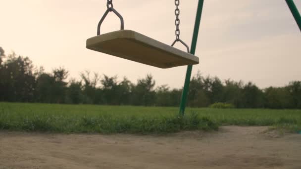 Медленное Движение Одиноких Раскачивающихся Качелей Парке Летнем Свете Заката — стоковое видео