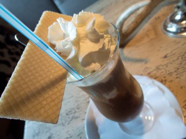 uzun bir bardak krem şanti ile lezzetli buzlu kahve