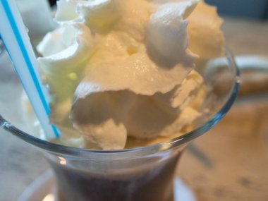 uzun bir bardak krem şanti ile lezzetli buzlu kahve