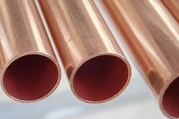 a close detail of many round copper pipes