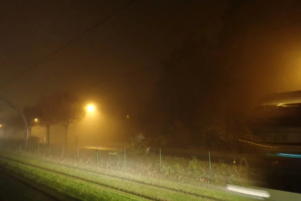 在雾蒙蒙的夜晚 交通的明亮灯光 — 图库照片