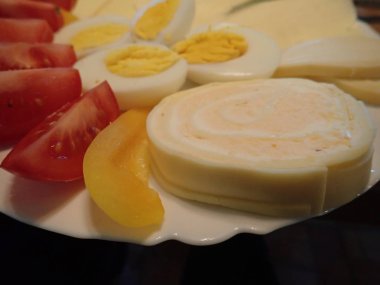 bir kahvaltı tabağı üzerinde yumurta ve sebze ile peynir