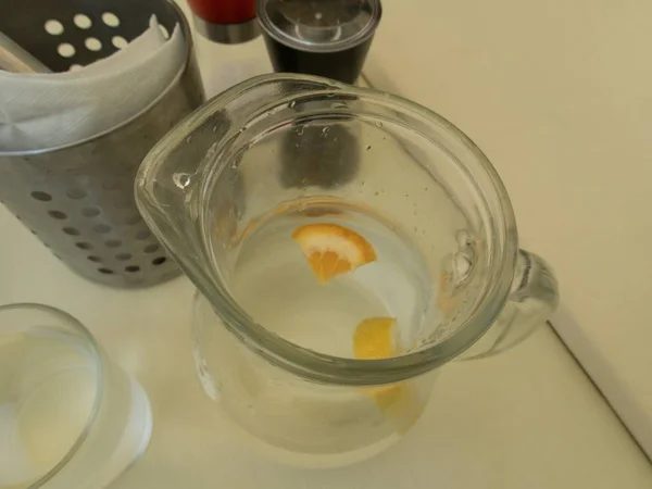 Tarro de agua con naranja en una mesa —  Fotos de Stock