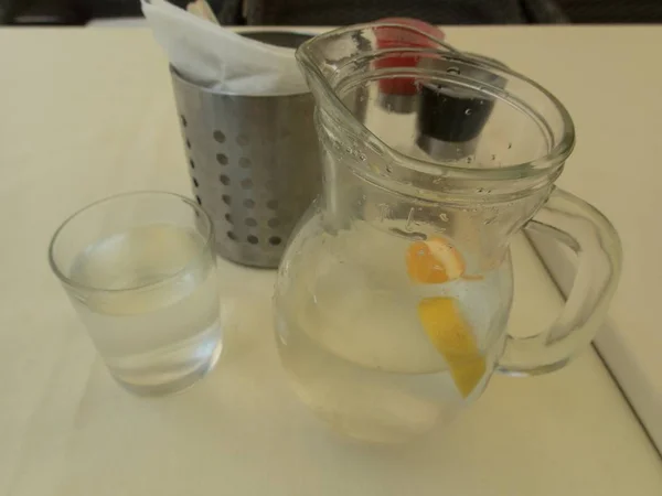 Glas Wasser mit Orange auf einem Tisch — Stockfoto