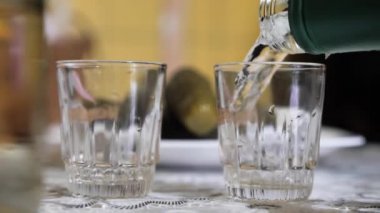 Kişi kazıklara votka döker. İçki dök.