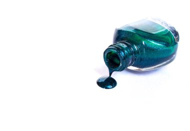 Beyaz arka planda izole edilmiş tırnak cilası şişeden akıyor..