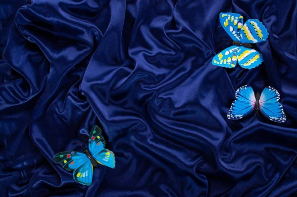 decorative butterflies on a blue silk background. top view