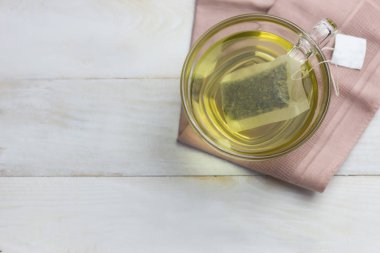 Beyaz ahşap zemin yerleştirilmiş cam sıcak yeşil çay.