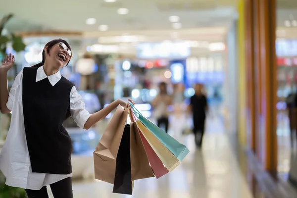 Happy woman enjoy shopping in the mall with shopping bags