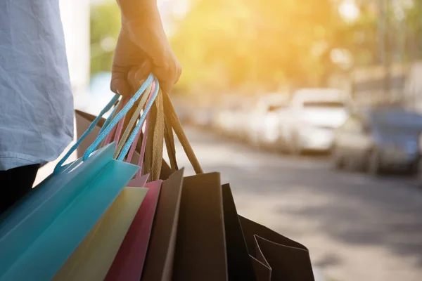 Alışveriş merkezinde alışveriş ve otopark için yürüyüş sonra alışveriş torbaları tutan kadın el